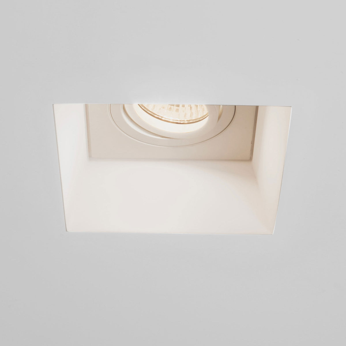 Square recessed ceiling light with a round, adjustable bulb in a white ceiling