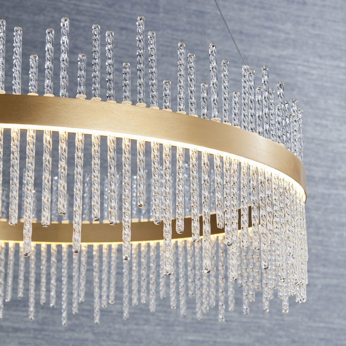 Close-up of the elegant LED chandelier, showcasing its intricate crystal rods and golden frame. Adds a touch of luxury.