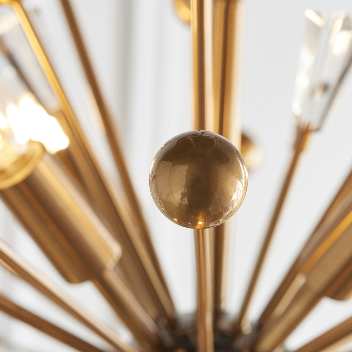 Close-up of a polished brass sphere detail on a sputnik-style chandelier.