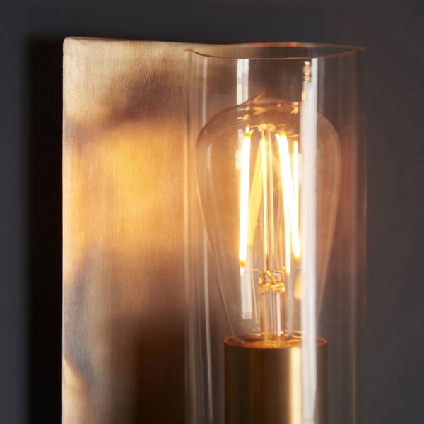 A close-up of the lit wall light against a dark wall, highlighting the warm glow.
