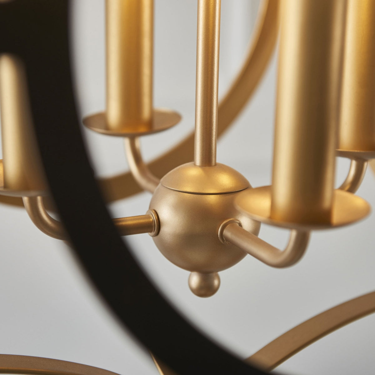 Close-up of the chandelier's gold candle-style lights and circular frame.
