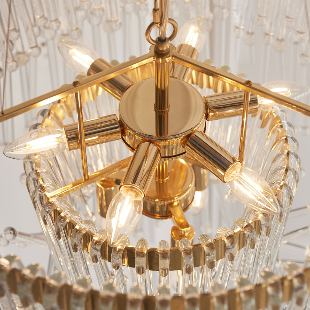 Close-up of the gold frame and light bulbs inside a clear glass chandelier.