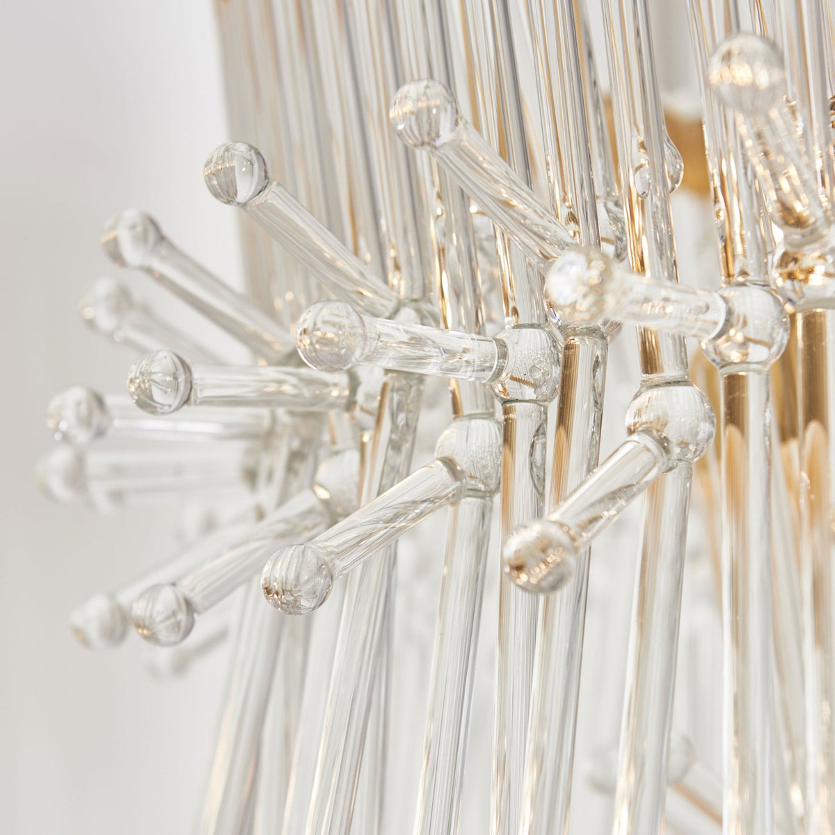 Detailed view of the clear glass rods with small bubbles on a chandelier.
