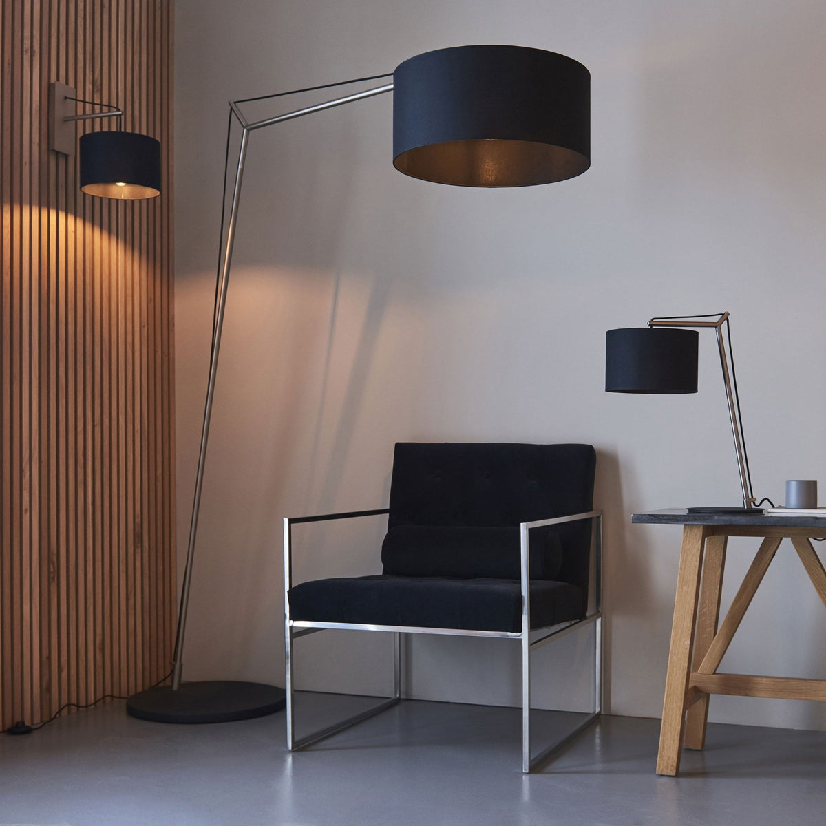 Living room with a black armchair, a floor lamp, a wall lamp, and a table lamp.