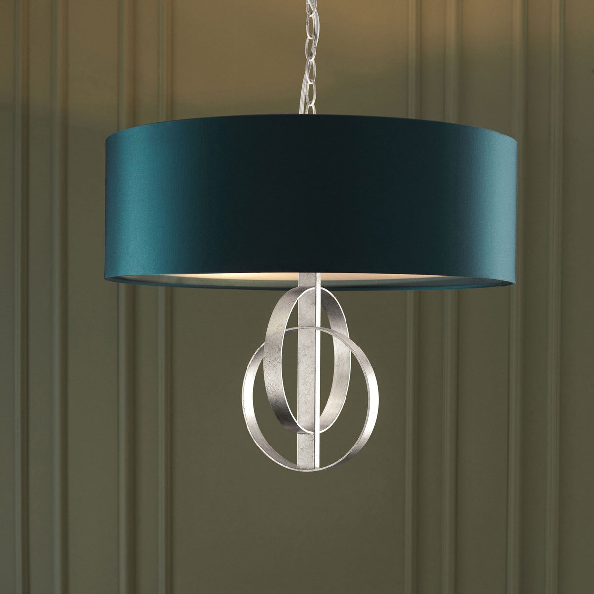 A close-up view of the contemporary ceiling pendant light with a teal fabric shade and brushed silver circles.