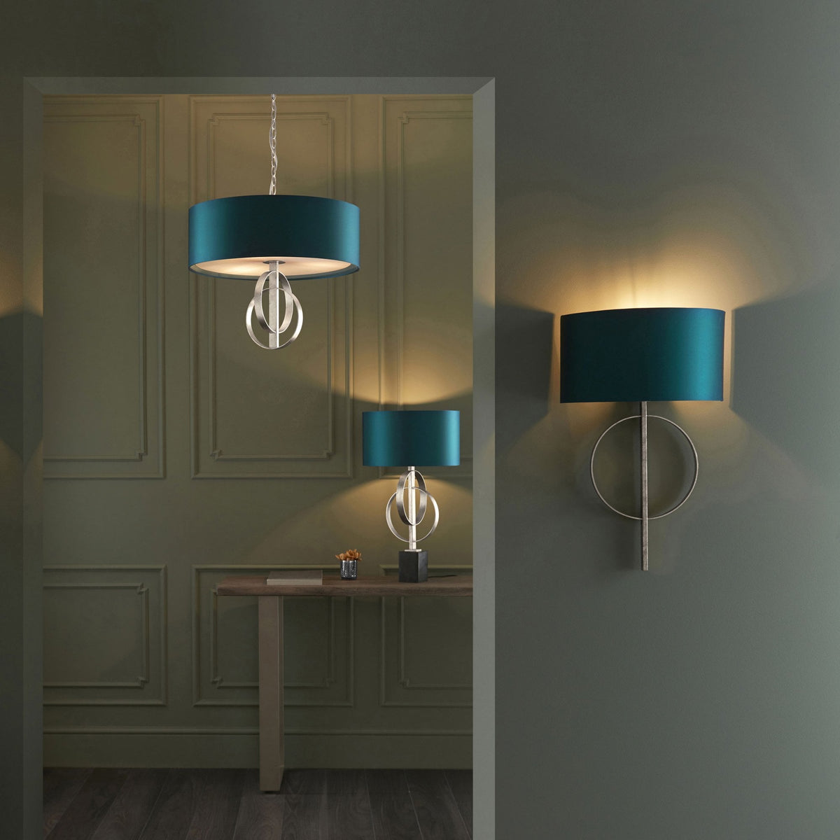 A set of matching teal and brushed silver lighting fixtures, including a pendant, table lamp, and wall light.