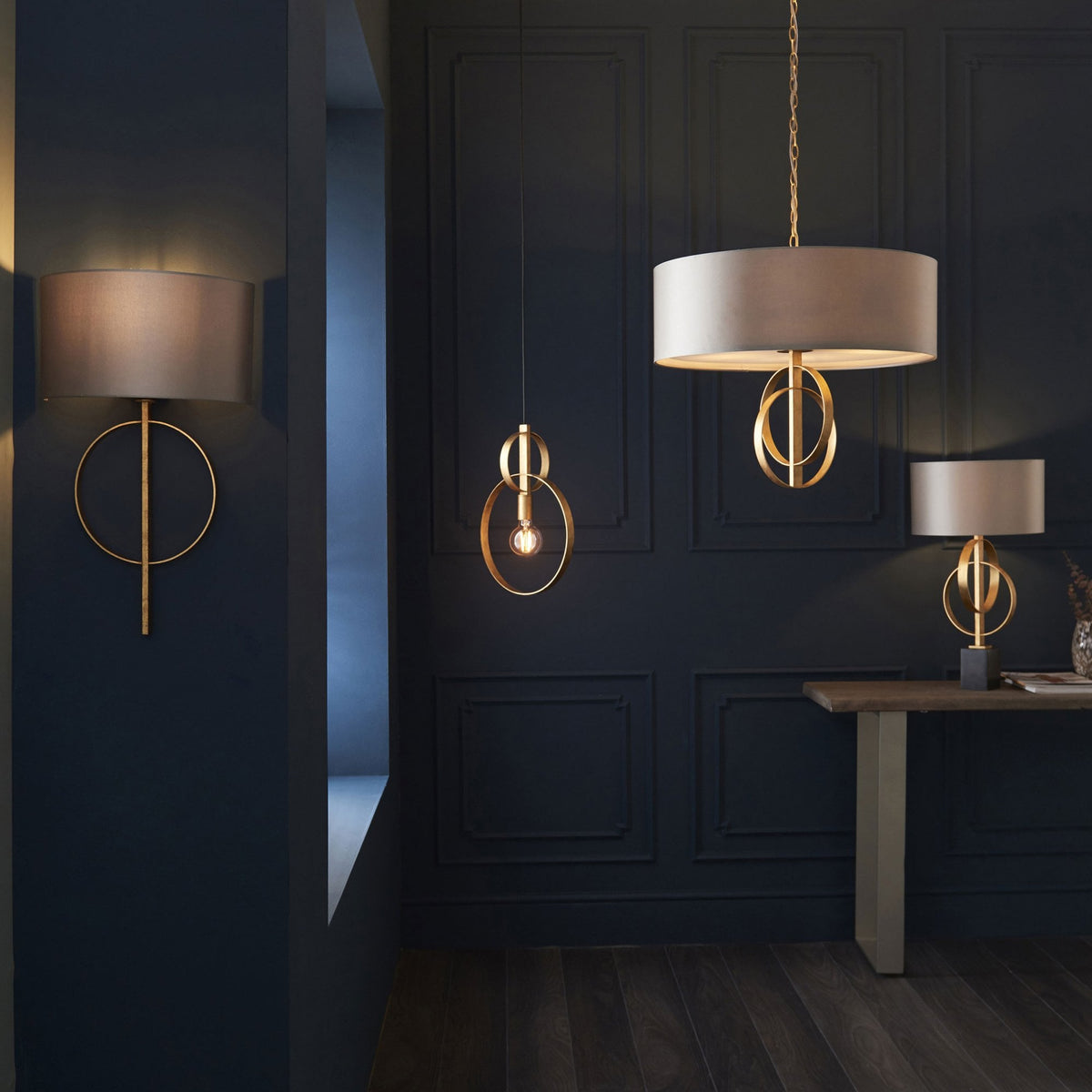 A collection of matching gold and cream lighting fixtures illuminating a sophisticated dark blue room.