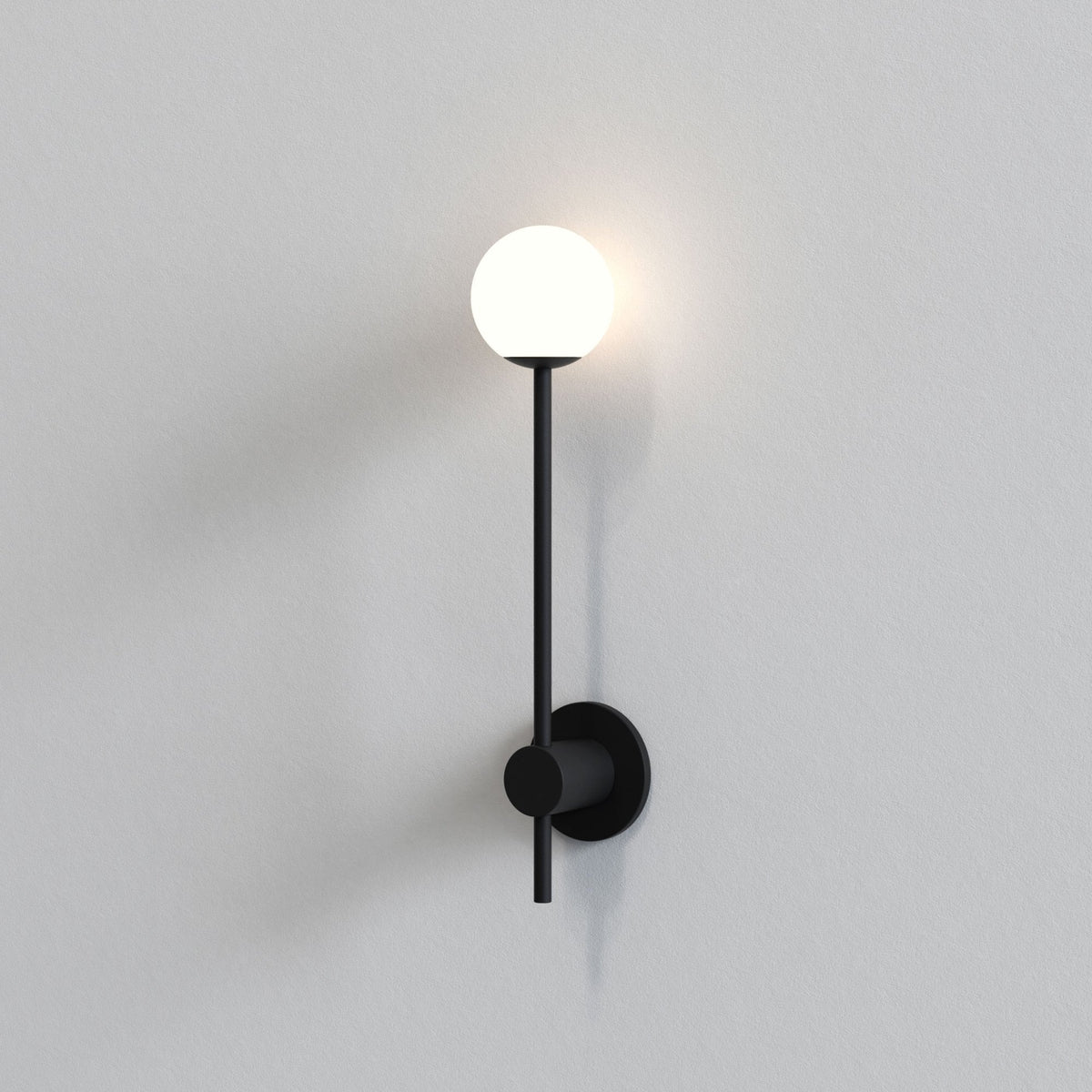 Black wall-mounted light fixture with a glowing spherical bulb