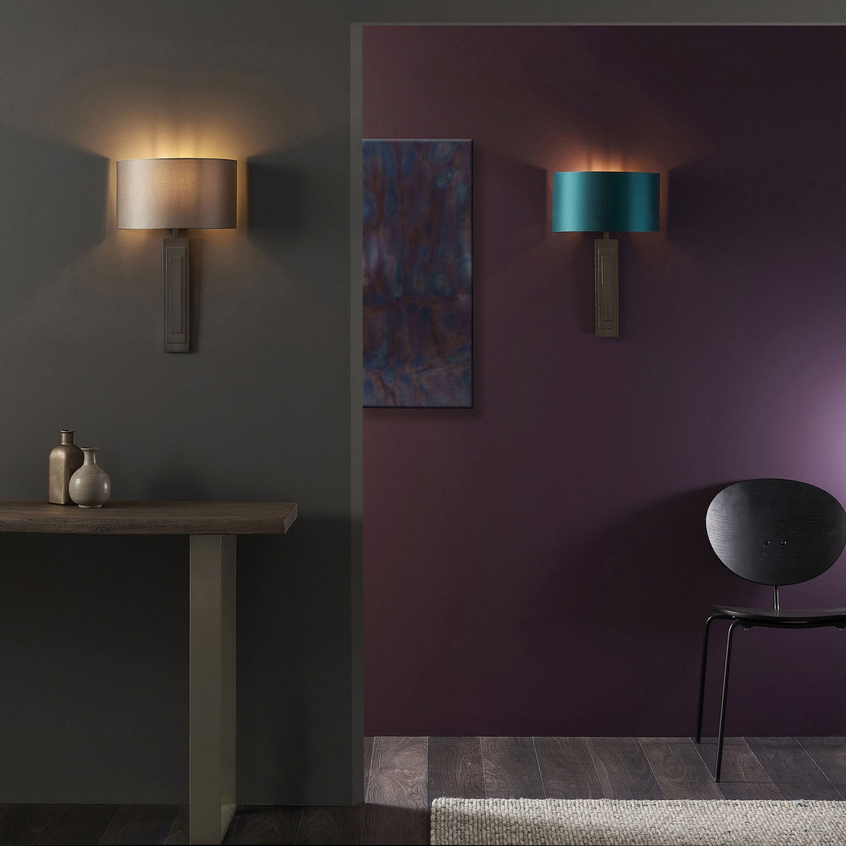 Two wall lights, one with a grey shade and one with a teal shade, illuminate a dark grey and purple room.