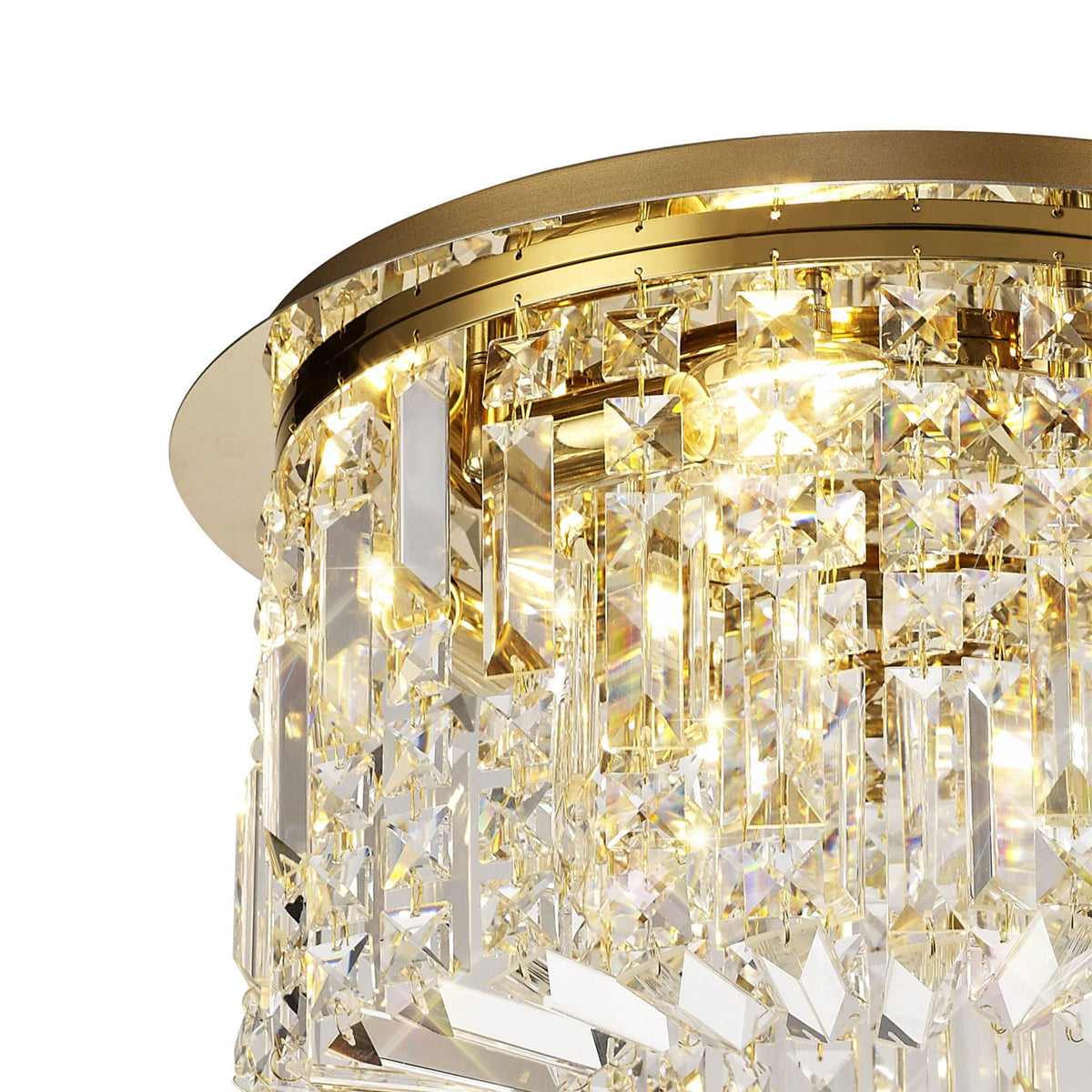 Angled view of the illuminated brass and crystal ceiling light from the left side.