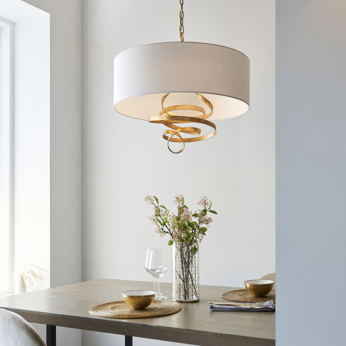 The pendant light hangs above a dining table, complementing the room's warm and inviting decor.