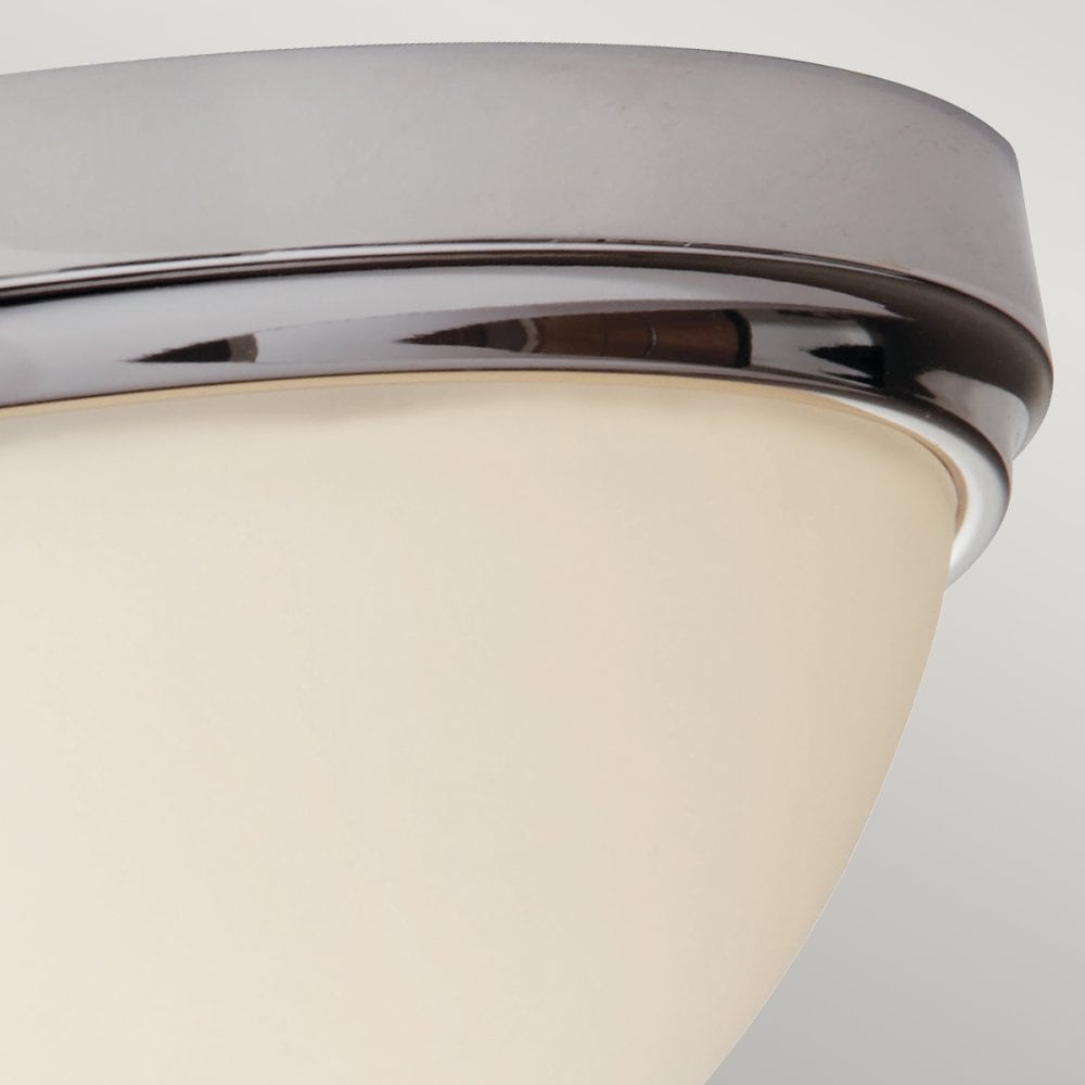 Close-up of the polished chrome trim and opal glass shade on a ceiling light.