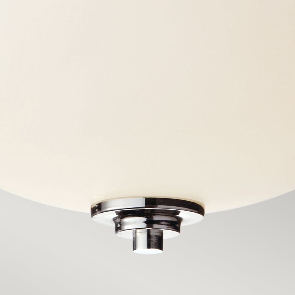 Detail of the chrome finial and opal glass shade of a semi-flush ceiling light.