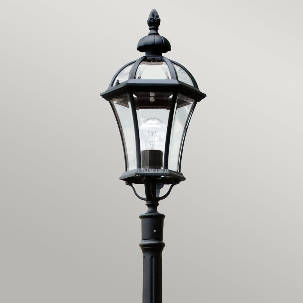 Close-up of a black street lamp's classic lantern head, showcasing its intricate details.