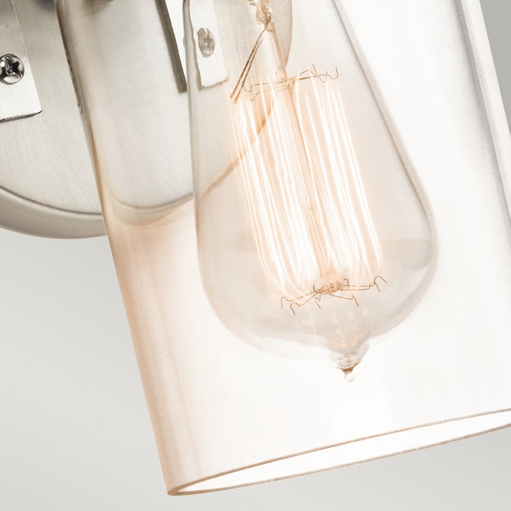 A detailed shot of the clear glass shade and exposed filament bulb of a wall sconce.