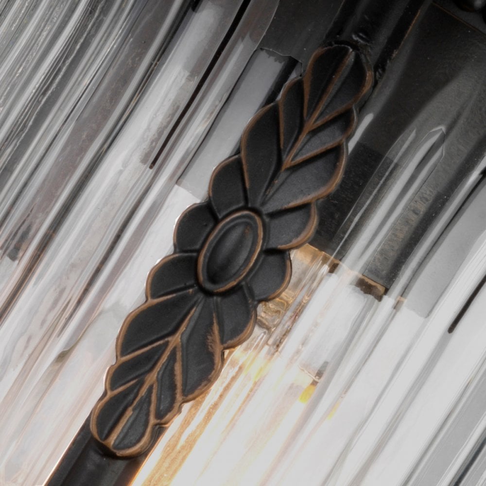 Close-up of the decorative metal leaf embellishment on the outdoor wall light's glass.