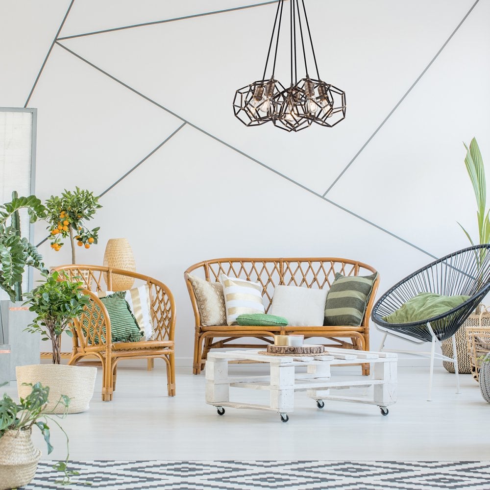 The contemporary cluster pendant illuminates a stylish living room with rattan furniture.