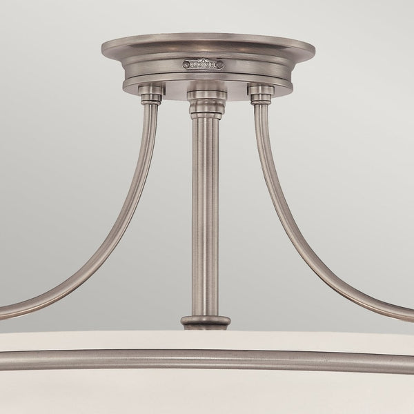A close-up of the mounting base and arms of the semi-flush ceiling light.