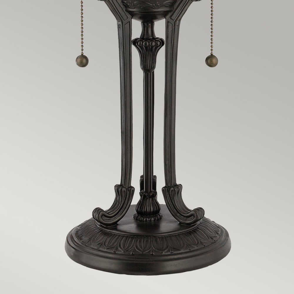 Detailed view of the dark, ornate metal base of a traditional table lamp.