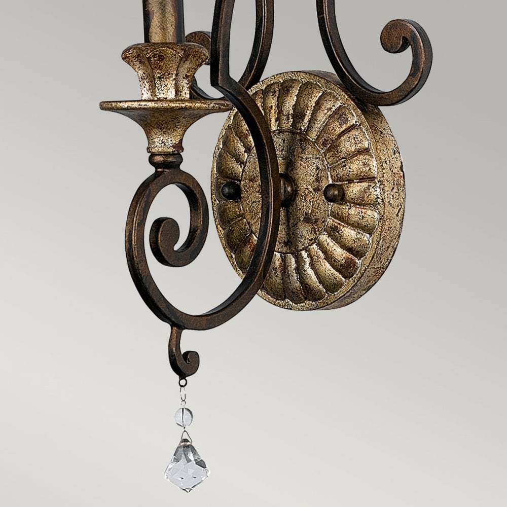 Detail of the vintage-style wall sconce's base, showing the textured plate and hanging crystal.