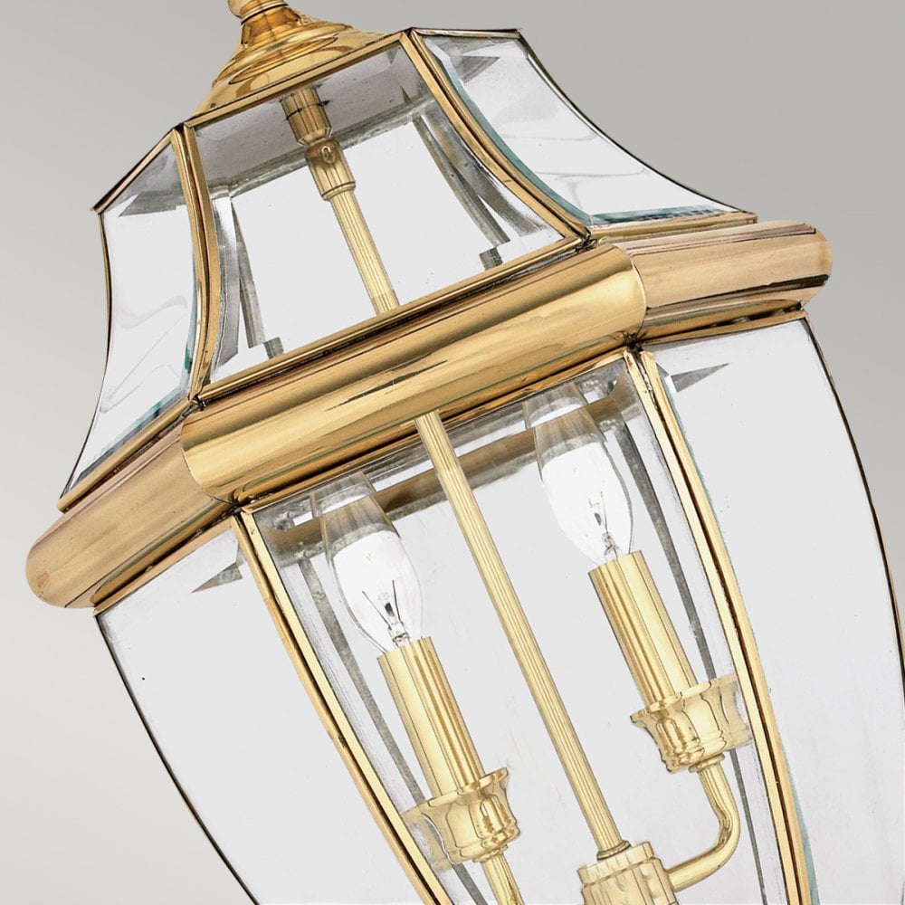 Close-up of a brass and glass hanging lantern showing two candle-style bulbs.
