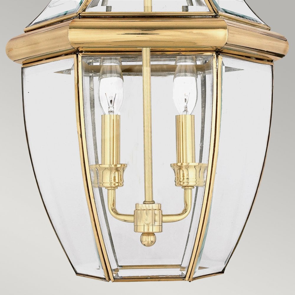 Detailed view of the lower half of a brass and glass lantern with two bulbs.