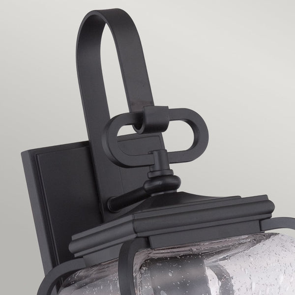Close-up of the decorative black mounting bracket and top of the outdoor wall light.
