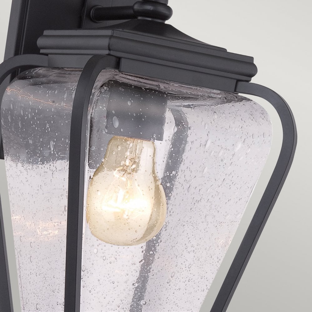 Detailed view of the clear seeded glass and exposed light bulb in the fixture.