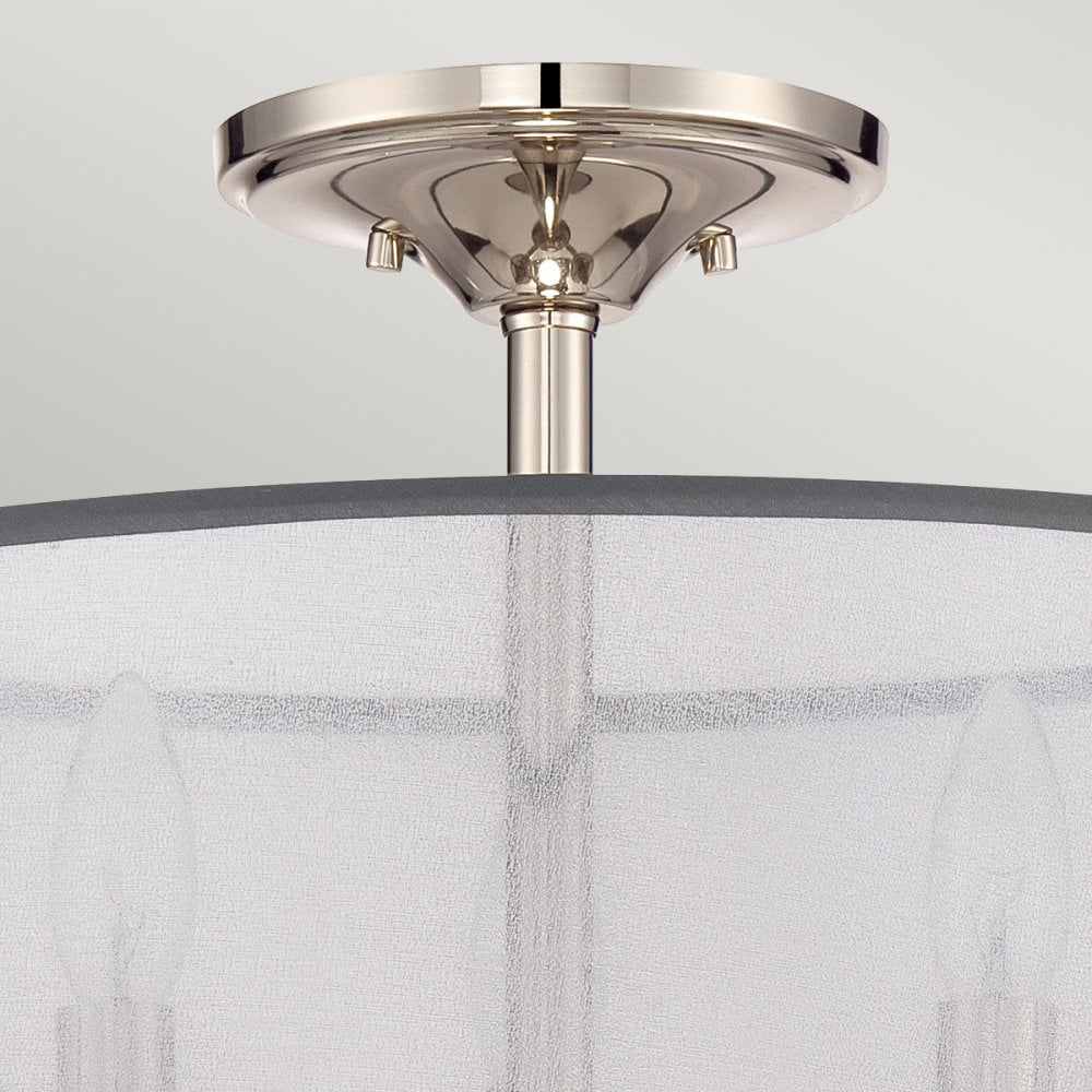 A close-up of the ceiling mount and top portion of a light fixture with a sheer shade.