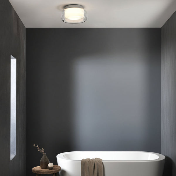 Modern bathroom with a white freestanding tub and a round ceiling light fixture
