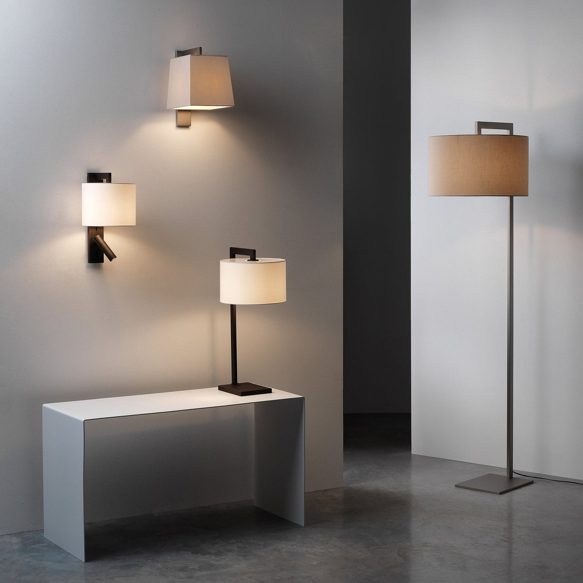 Three wall lamps, a table lamp, and a floor lamp with fabric shades and dark metal bases