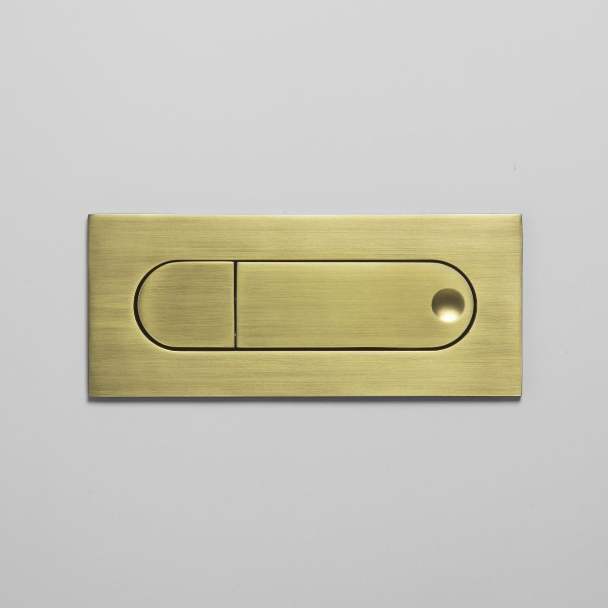 Brushed brass flush plate with two buttons, one small and one large with a circular indentation