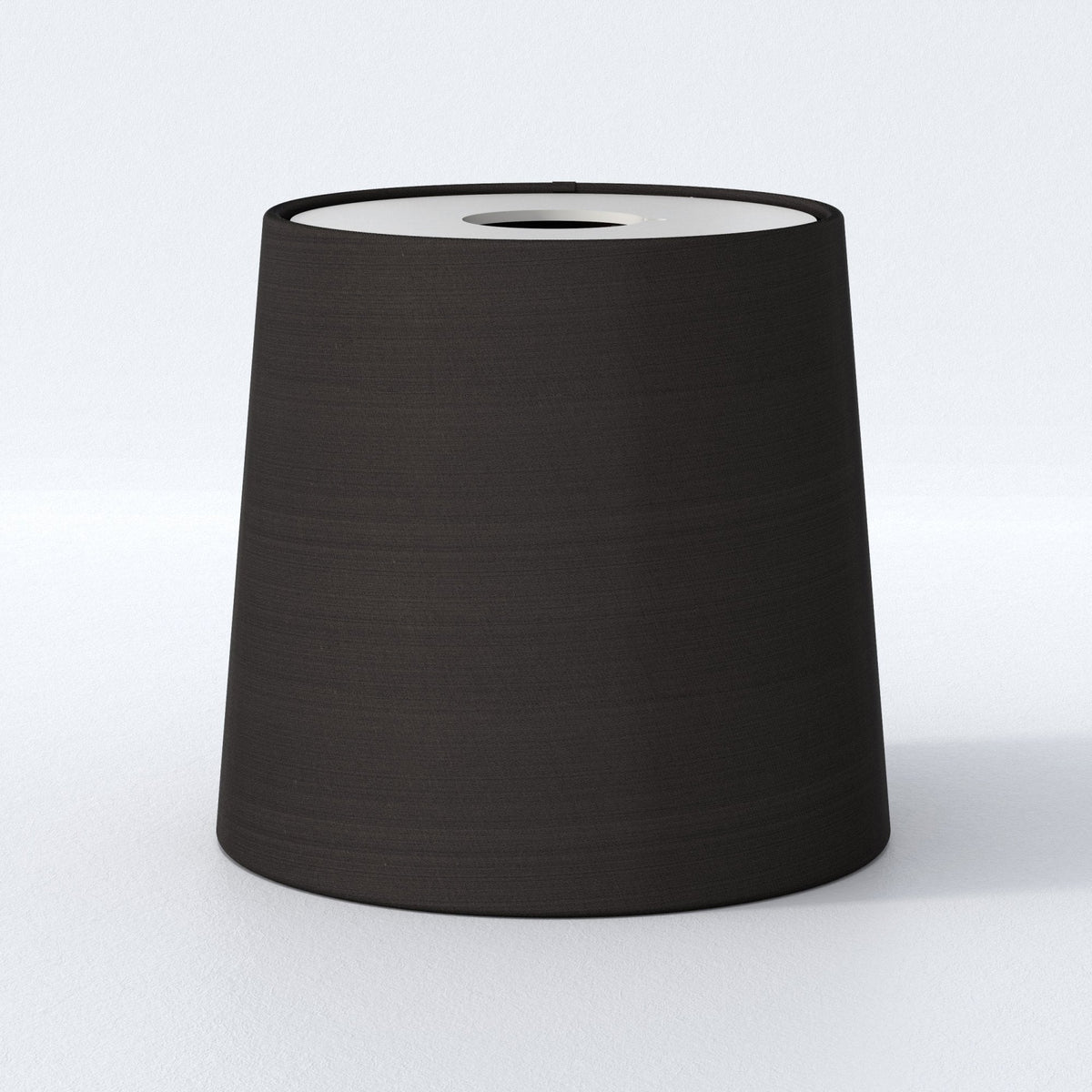 Black tapered drum lampshade with a white interior
