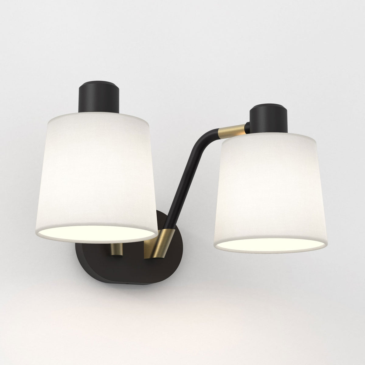 Two-light wall sconce with black metal frame and white conical fabric shades