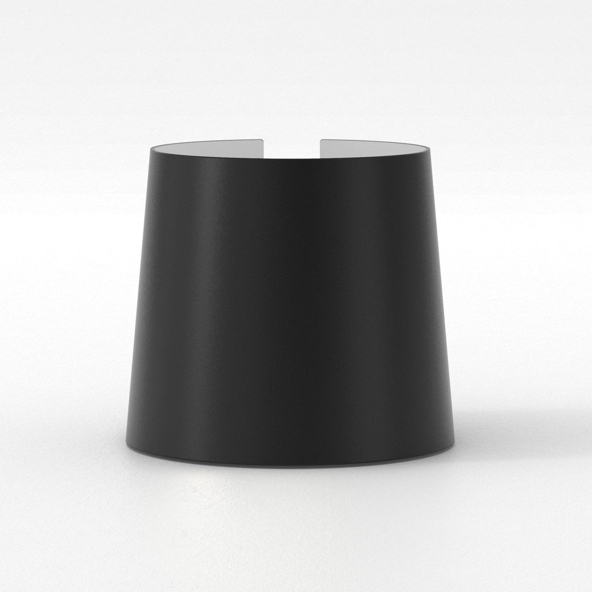 Black cylindrical object with a slight taper, open at the top with a small notch