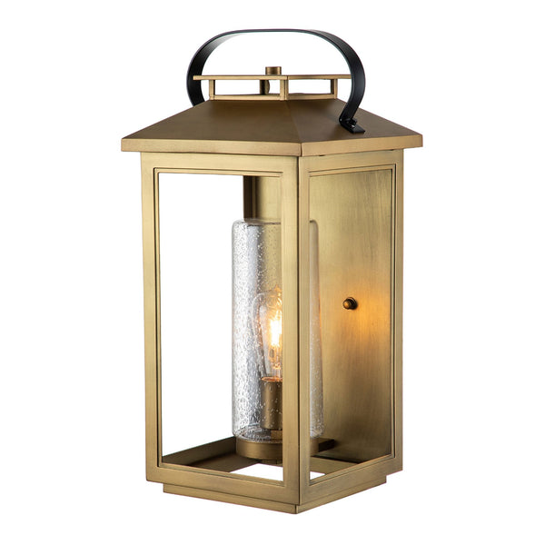 A brass outdoor wall lantern with a clear seeded glass cylinder and a single exposed bulb.