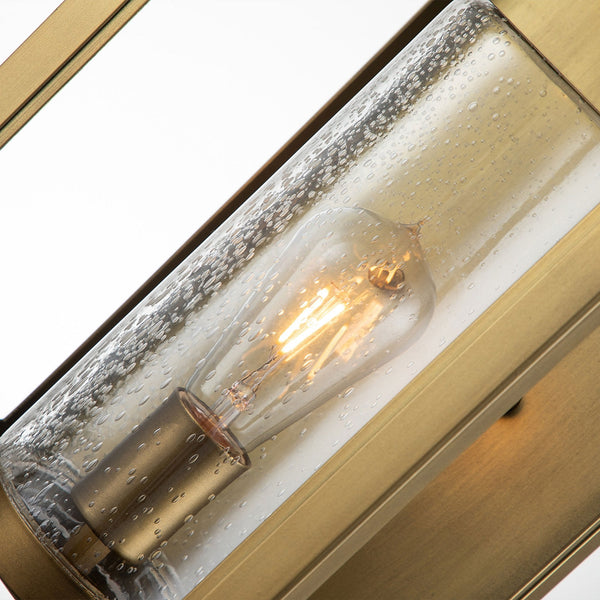 Close-up of the seeded glass cylinder and filament bulb inside the brass lantern.