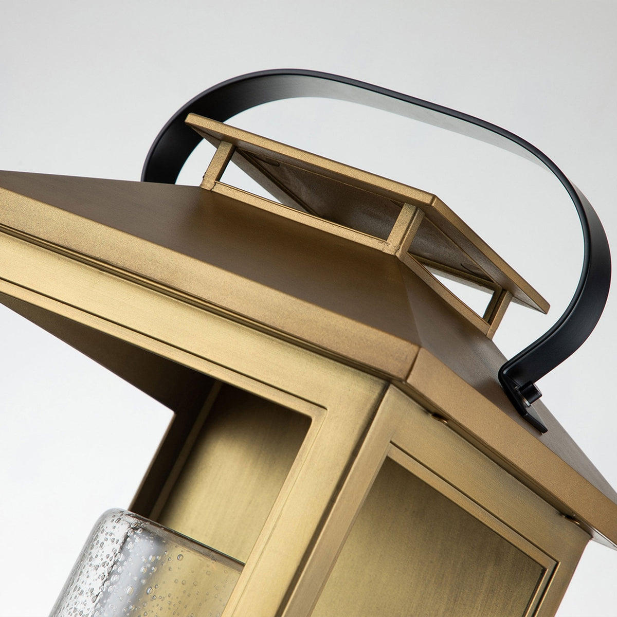 Top view of the brass lantern, showing the handle and the layered roof design.