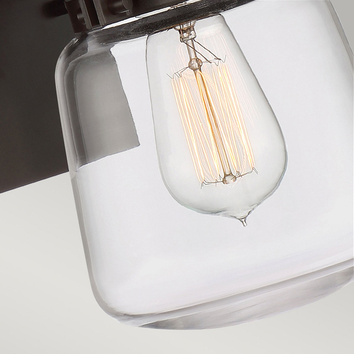 Close-up of the filament bulb inside the clear glass jar of the light.
