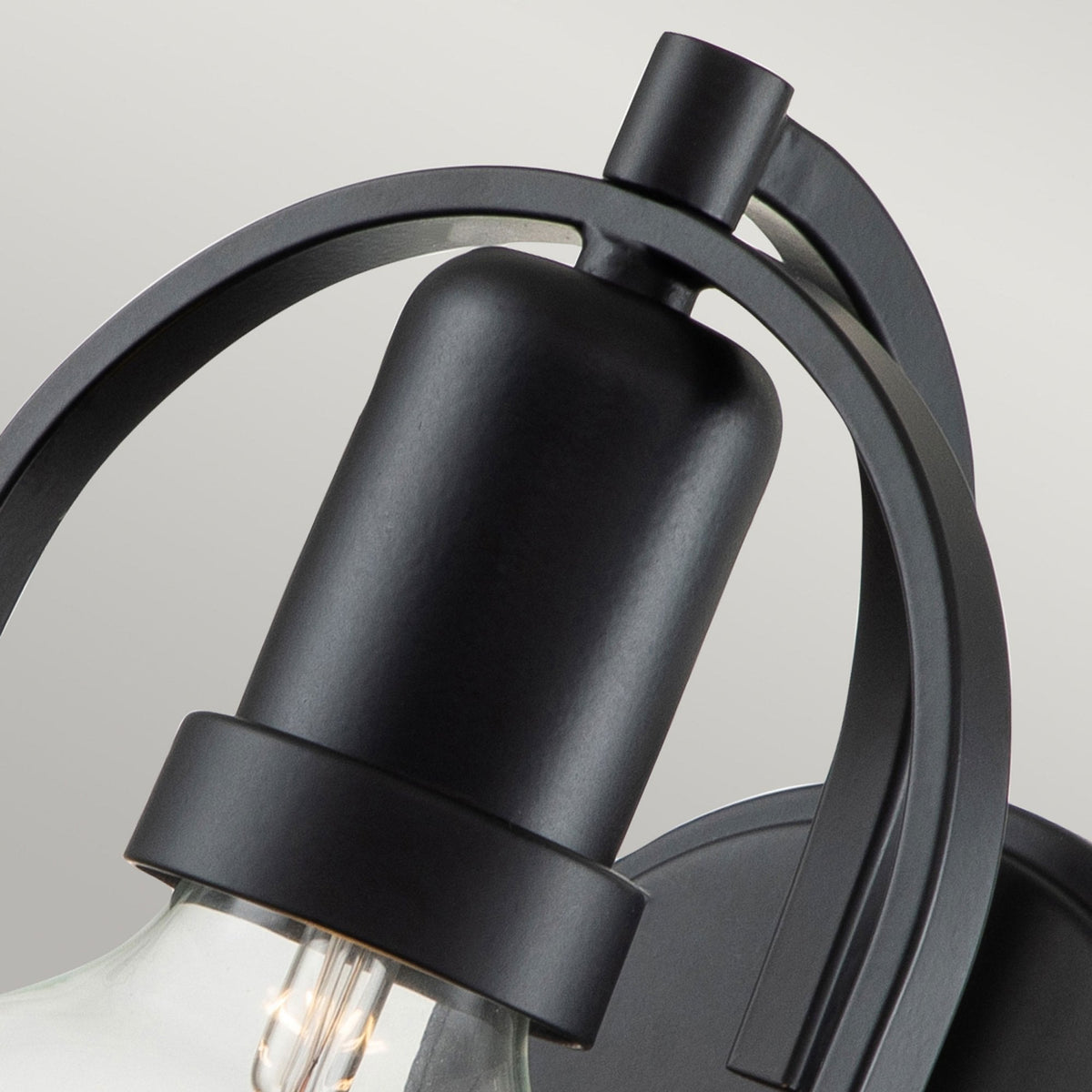 Close-up of the black metal frame and fixture holding the light bulb.