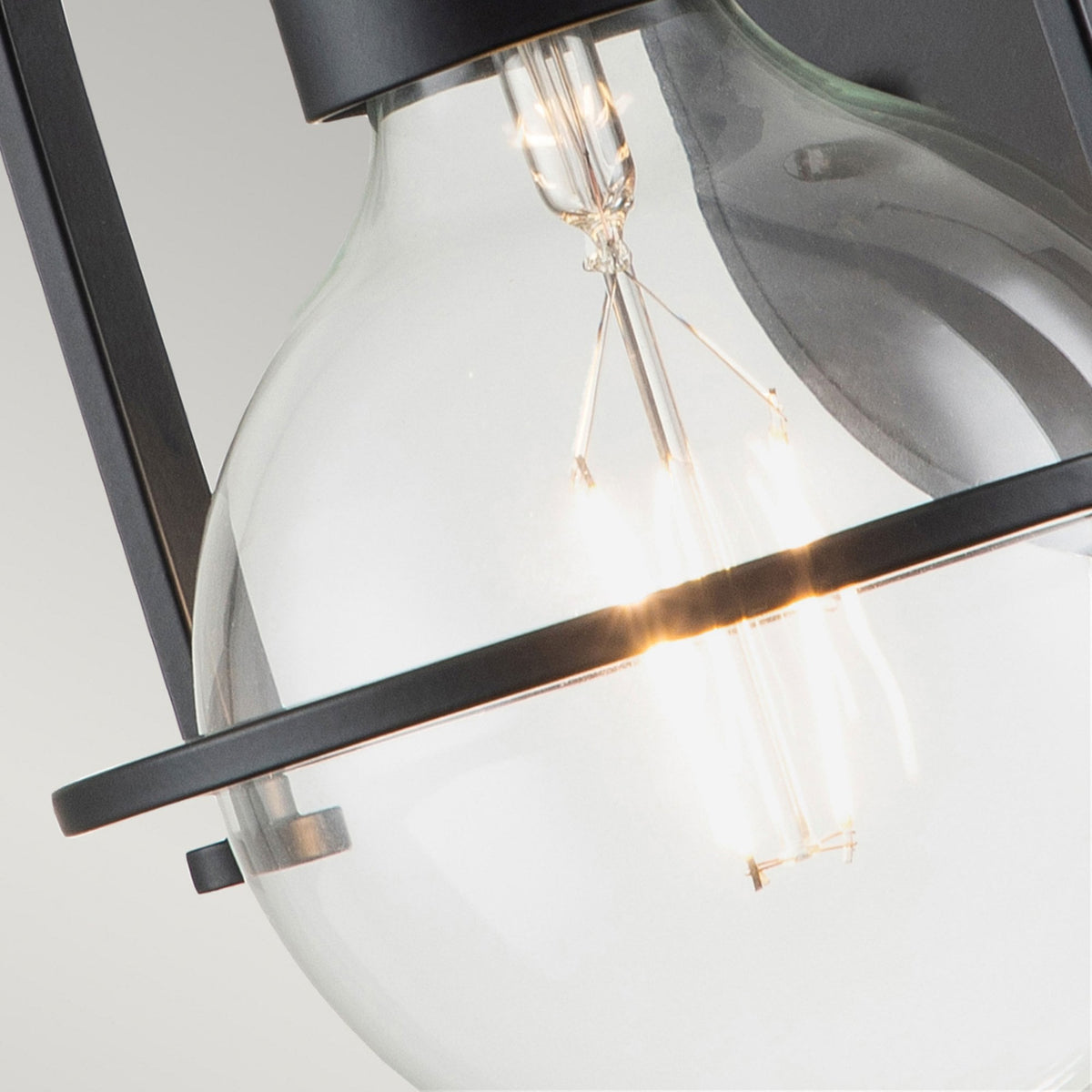 Close-up of the clear glass shade and the illuminated filament bulb inside.