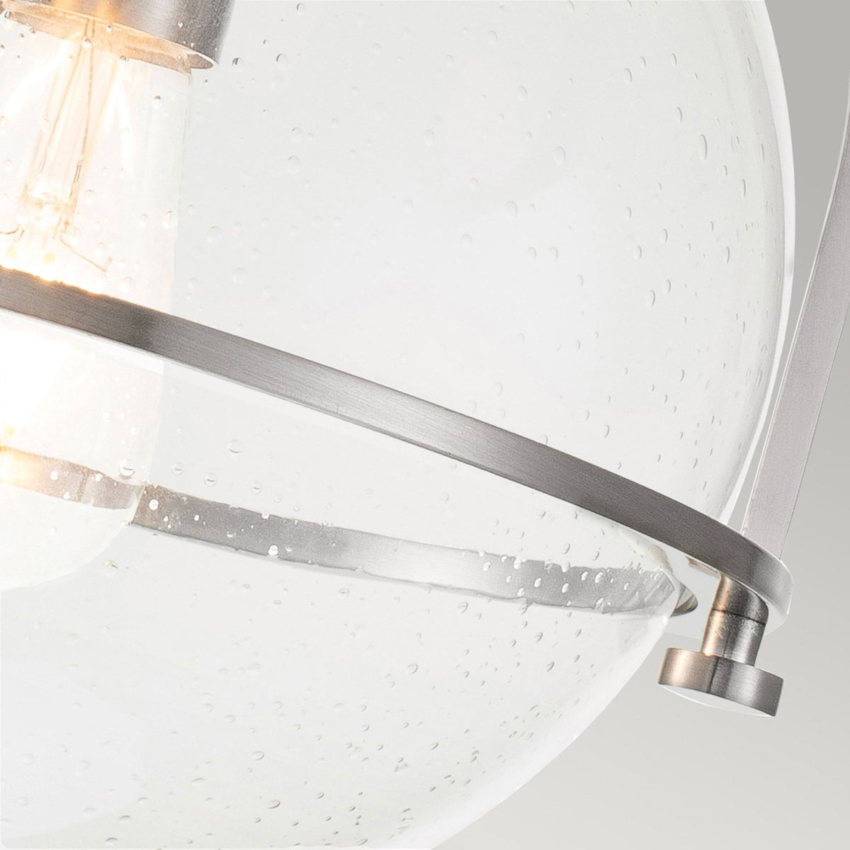 A detailed view of the seeded glass and brushed nickel banding on the light fixture.