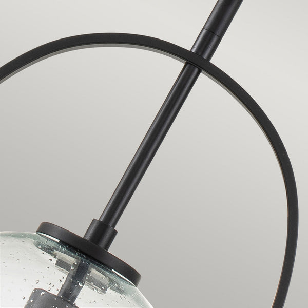 Close-up of the black metal frame and clear seeded glass shade of the pendant light.