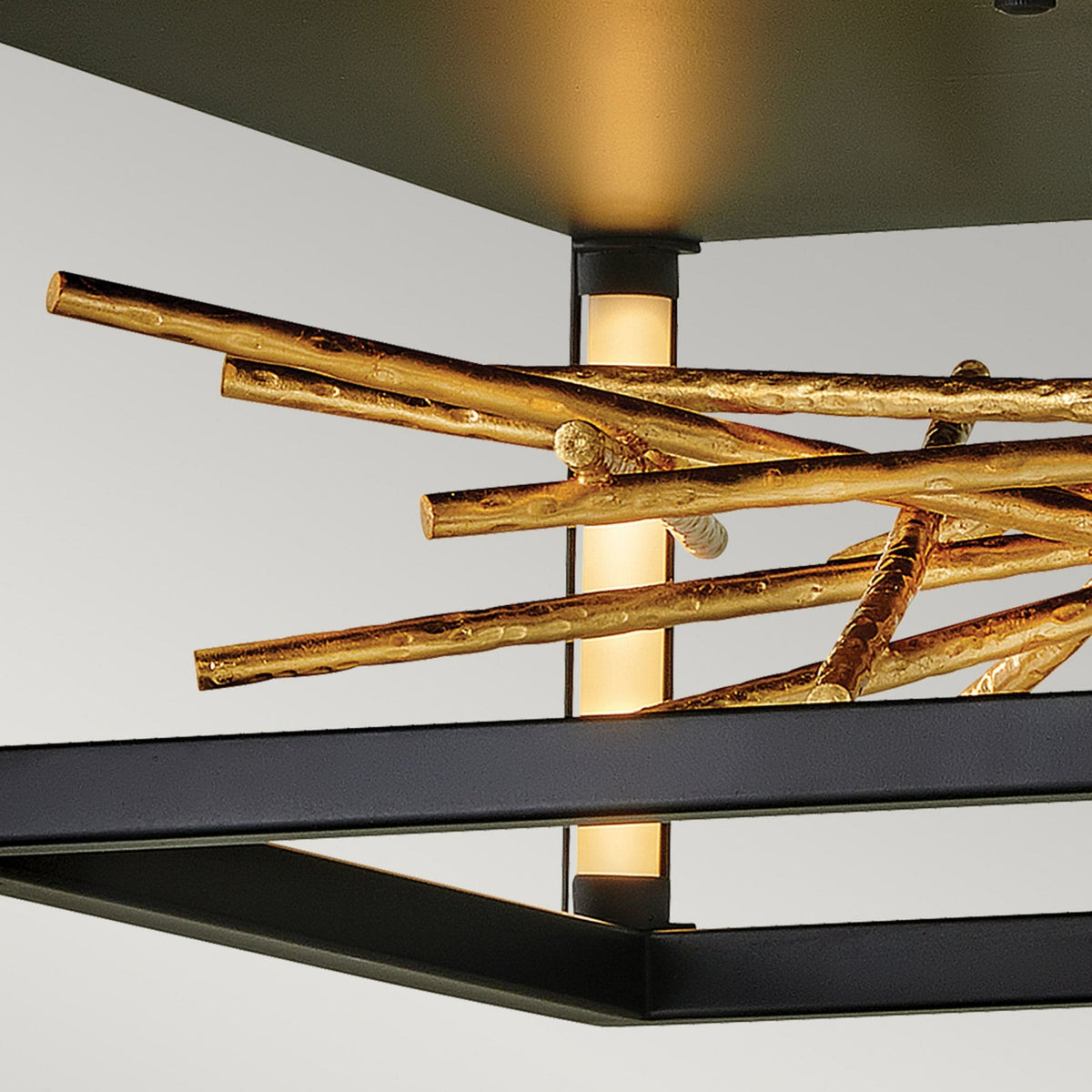 Close-up of the light showing a glowing vertical element within the gold twig design.