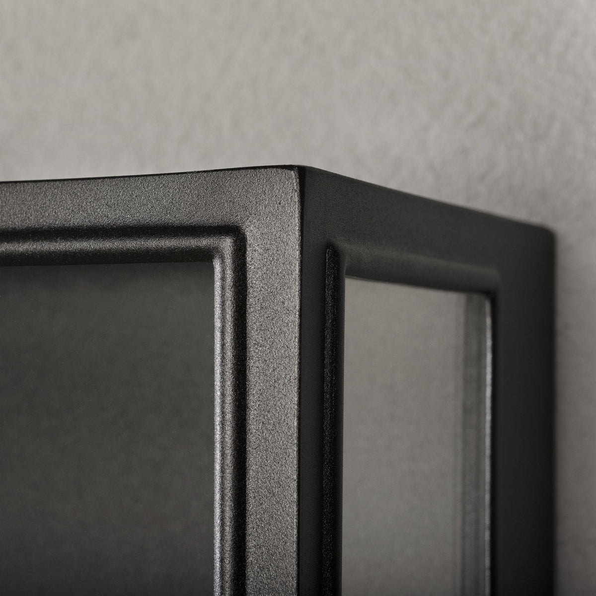 A detailed close-up of the textured black finish and corner of the outdoor wall light.