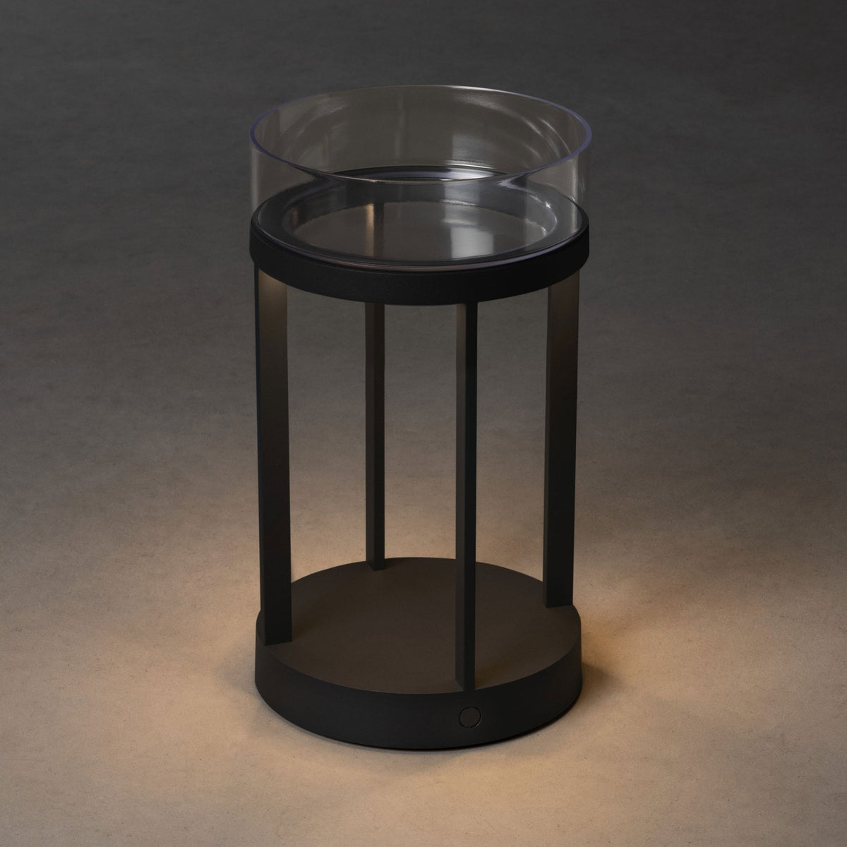 A black and clear modern lantern with a subtle glow at its base.