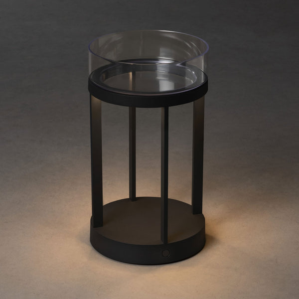 A black and clear modern lantern with a subtle glow at its base.