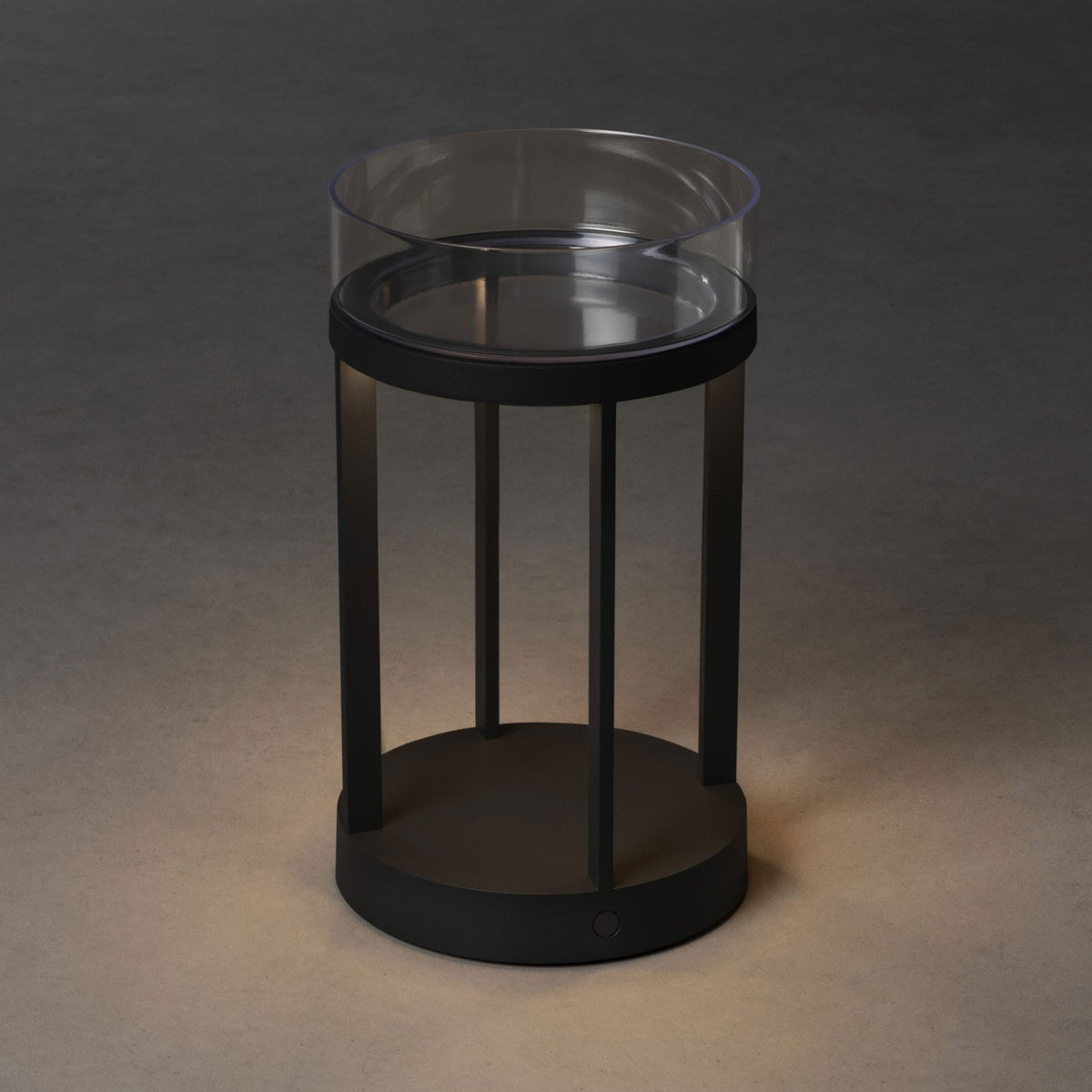 A black cylindrical lantern with a transparent top, featuring a soft upward glow.