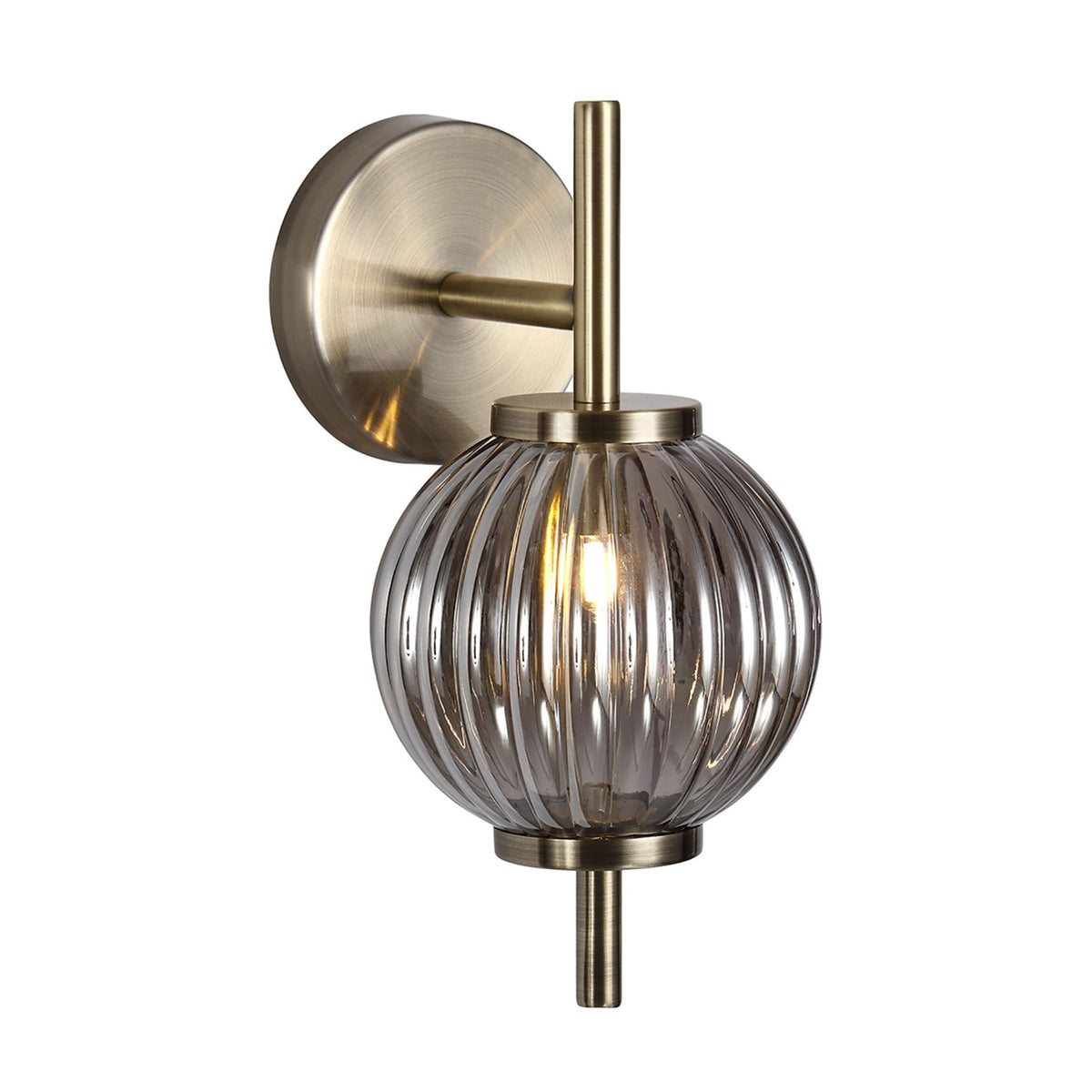 Ribbed smoked glass wall light with antique brass fittings against a white background.