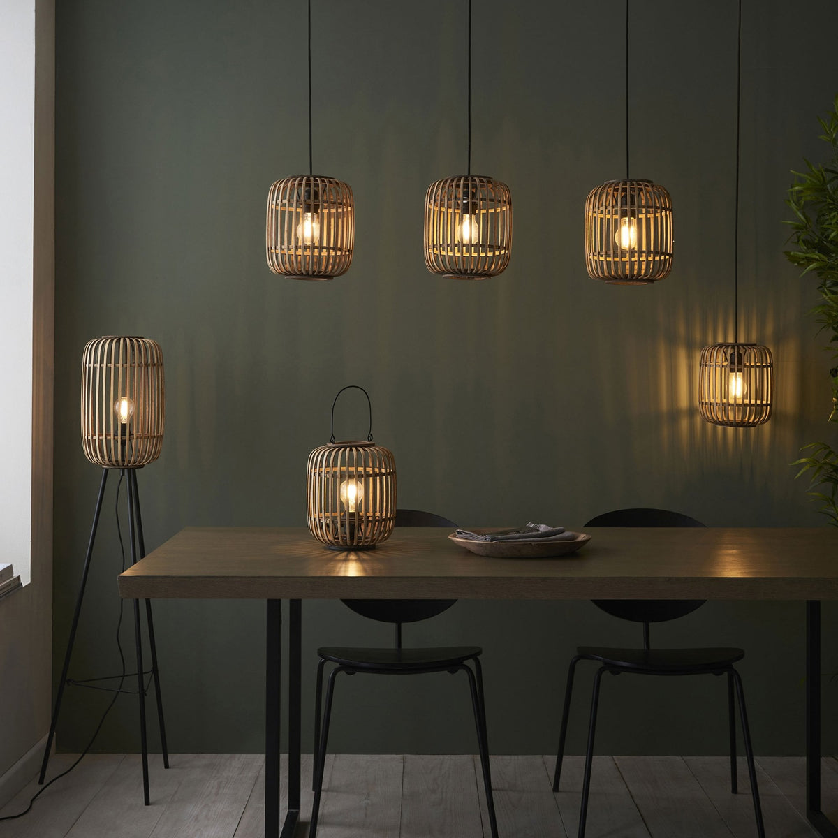 A dining area featuring various bamboo cage lighting fixtures.